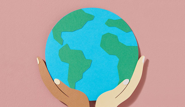 Une illustration d'un globe terrestre soutenu par une main noire et une main blanche.