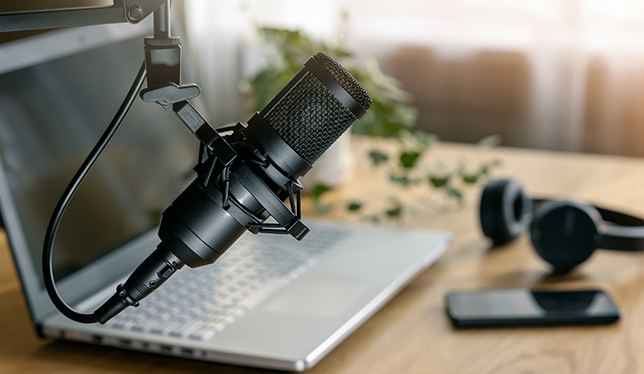 A laptop, microphone and headphones